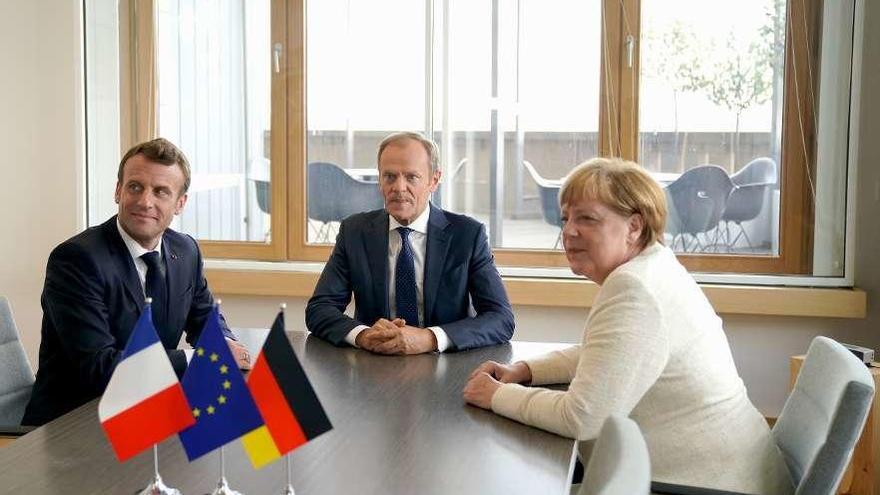 Macron, Tusk y Merkel, ayer, en Bruselas, en una reunión en las horas previas a la cumbre. // Reuters