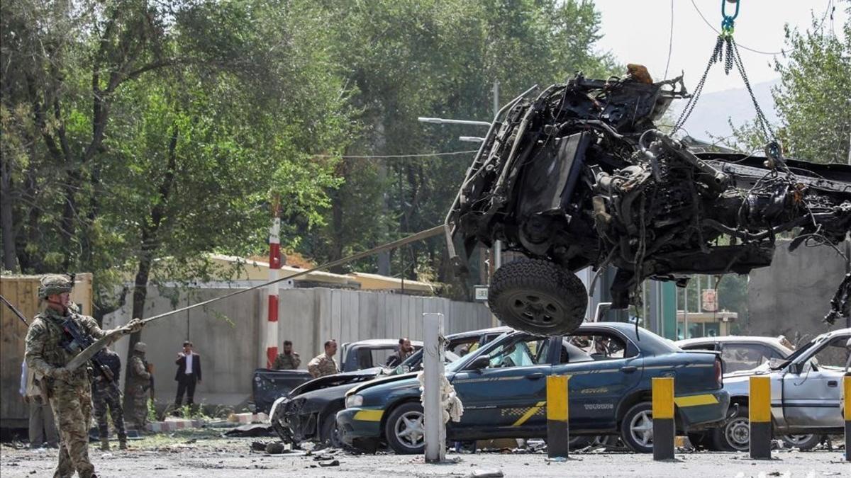 Soldados de la OTAN retiran uno de los vehículos siniestrados en un atentado suicida en Kabul.