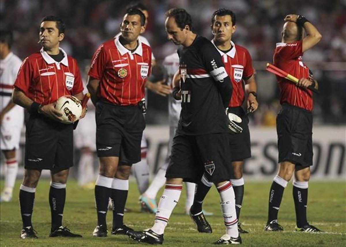 El porter del São Paulo, Rogerio Ceni, i el trio arbitral esperen en va la sortida de Tigre per iniciar la segona part.