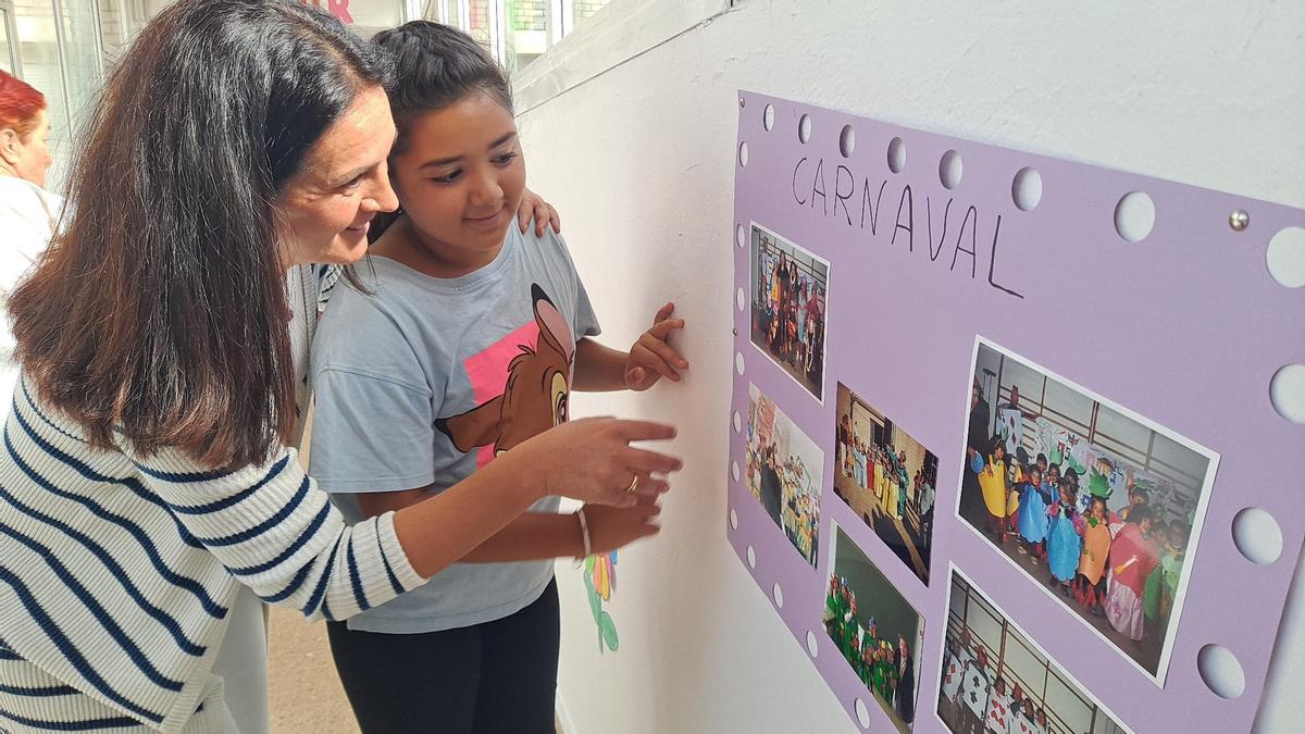 Soledad enseña a una profesora la fotografía donde aparece su madre, que también estudió en el centro.