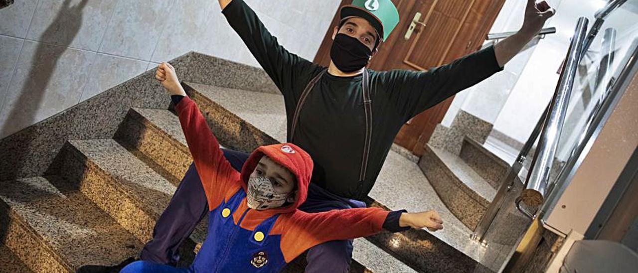 Dani Rogel y su hijo Enol, en su portal, vestidos de Luigi y Mario Bros.