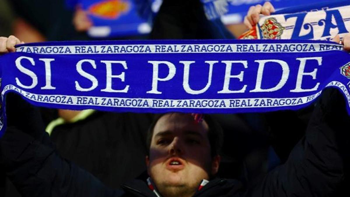 Un aficionado levanta una bufanda con la inscripción 'Sí se puede' en el Ibercaja Estadio.