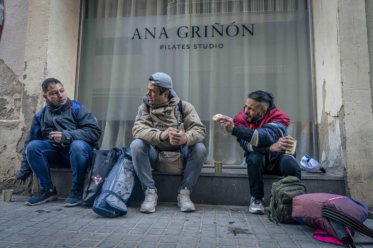Willy, en el centro, y Jonathan, a la derecha, ofrecen comida a un amigo.