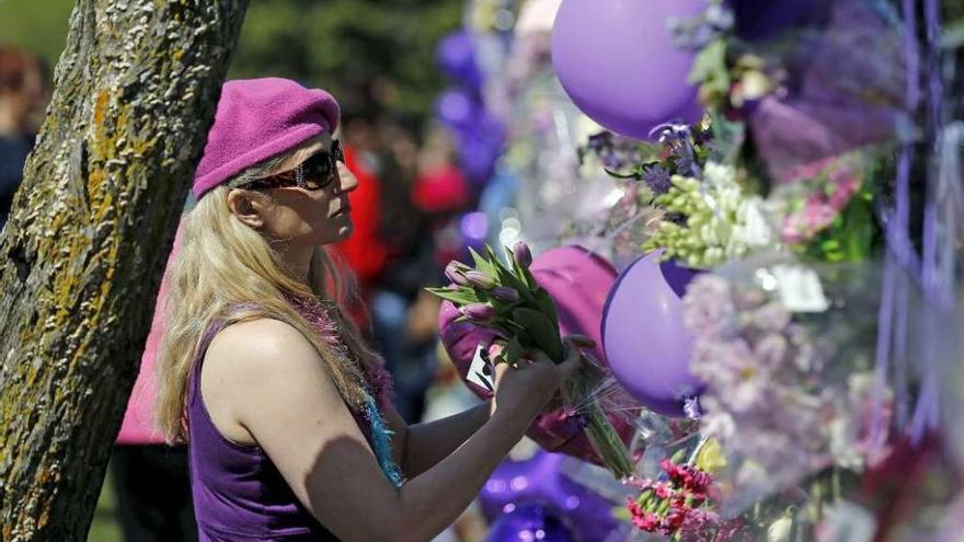 Una fan deposita flores en la valla de la residencia de Prince.