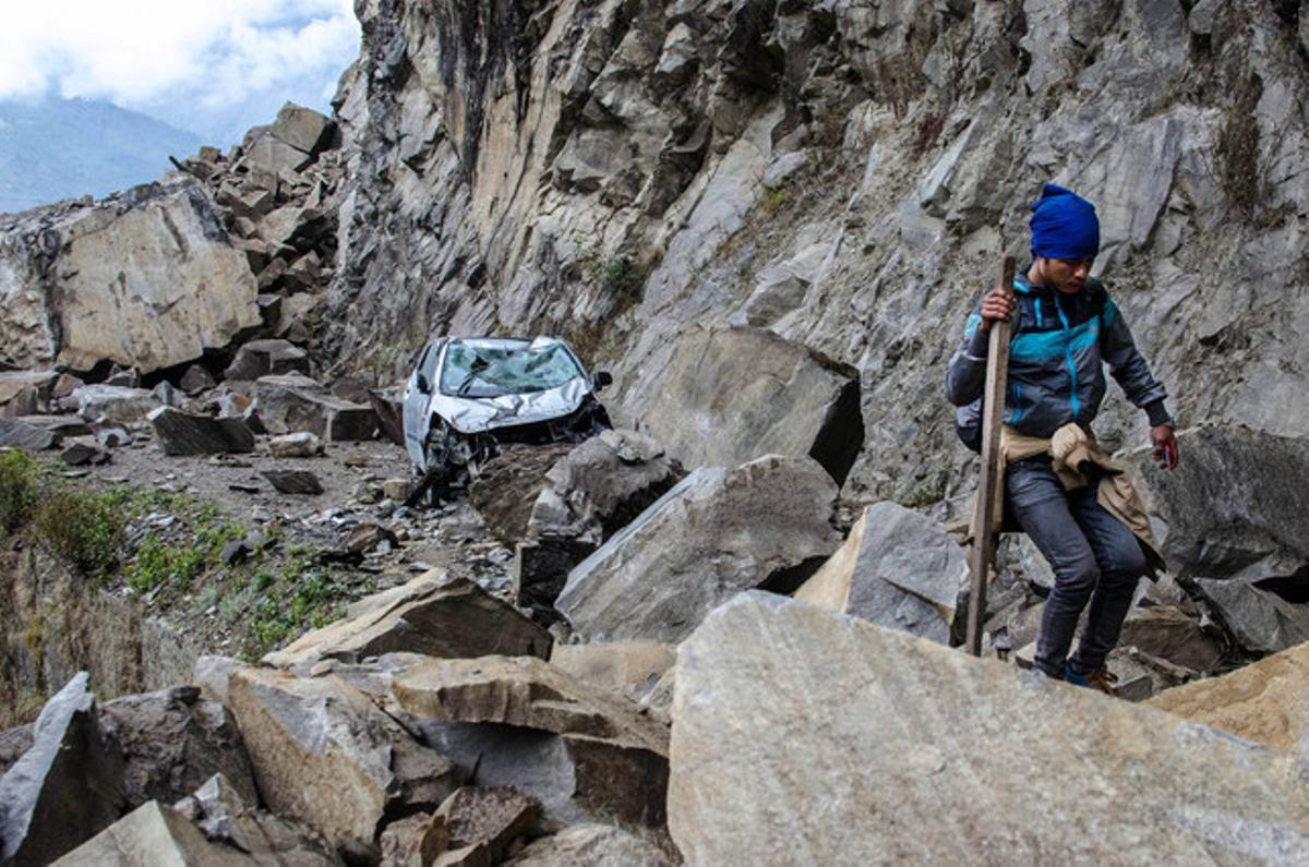 Un nepalès intenta desplaçar-se entre les roques caigudes a la vall de Langtang, un dels més afectats pel terratrèmol del Nepal.