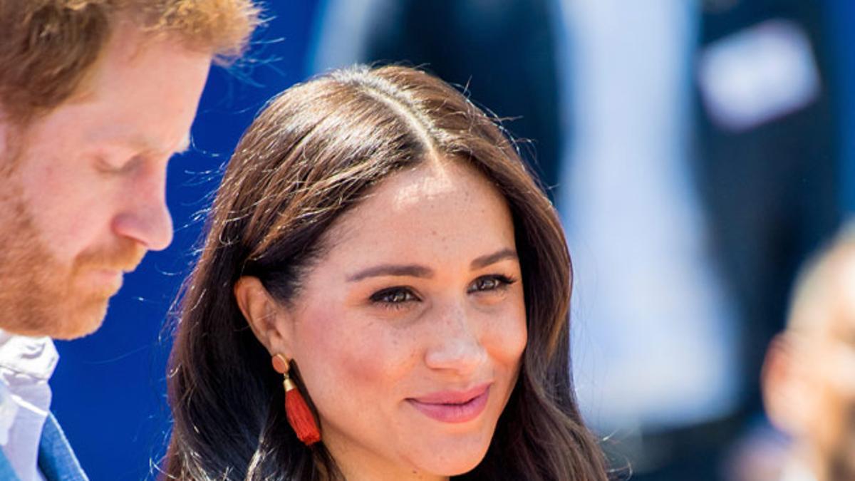 Meghan Markle con vestido camisero blanco y el príncipe Harry en África