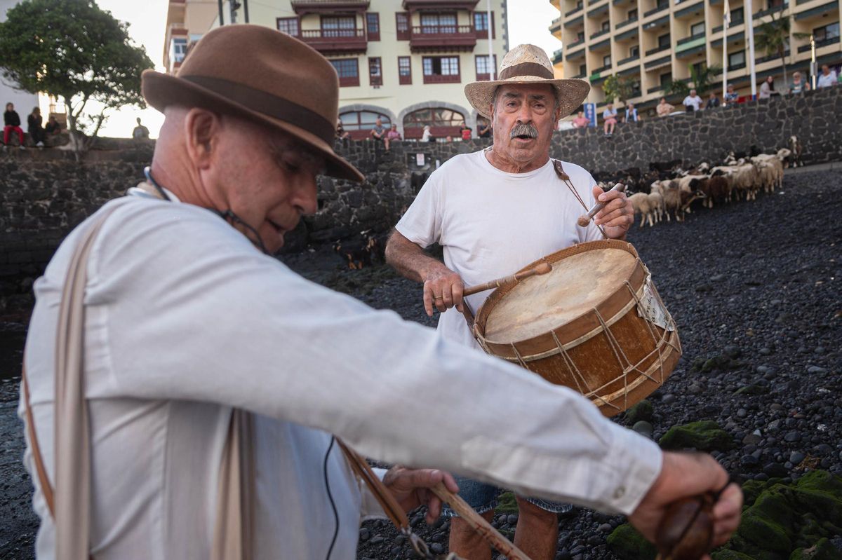 Domingo, de Tigaiga (Los Realejos), y Juan, de Tacoronte, a la derecha, amenizan al ritmo de tajaraste el baño de cabras.