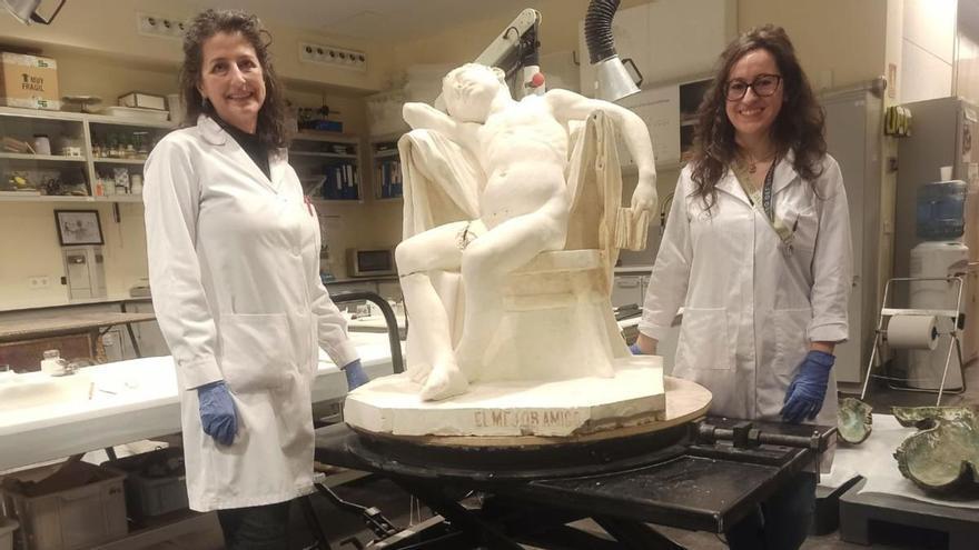 Sonia Tortajada y Sonia Lafuente, restauradoras, muestran la escultura en la que están trabajando, «El mejor amigo», de  Manuel Menéndez Entrialgo.