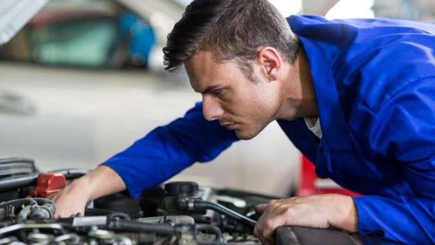 Un mecánico repara un automóvil.