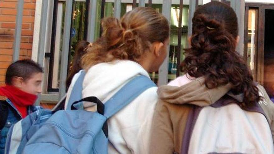 Un grupo de menores, a la entrada de un centro escolar.