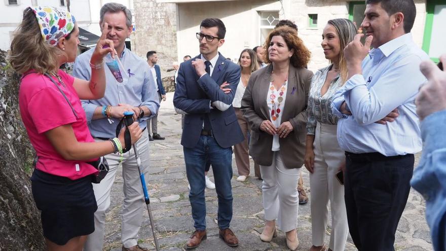 Una peregrina en Padrón con José Miñones, izquierda, y otras autoridades asistentes al acto