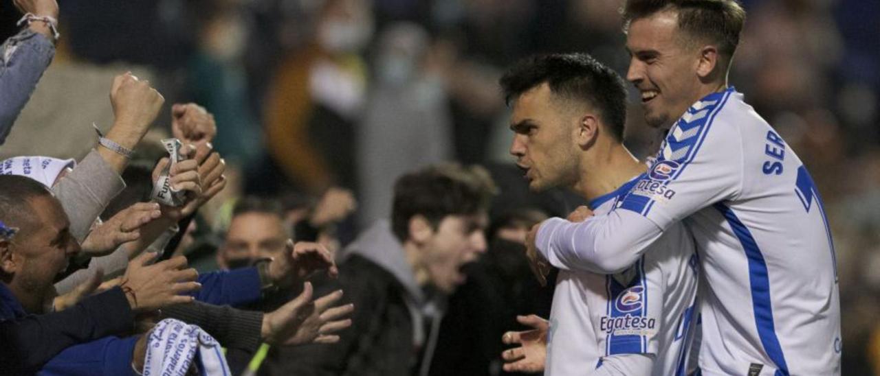 Álex Bermejo y Sergio González, celebrando el segundo gol del Tenerife con aficionados blanquiazules.