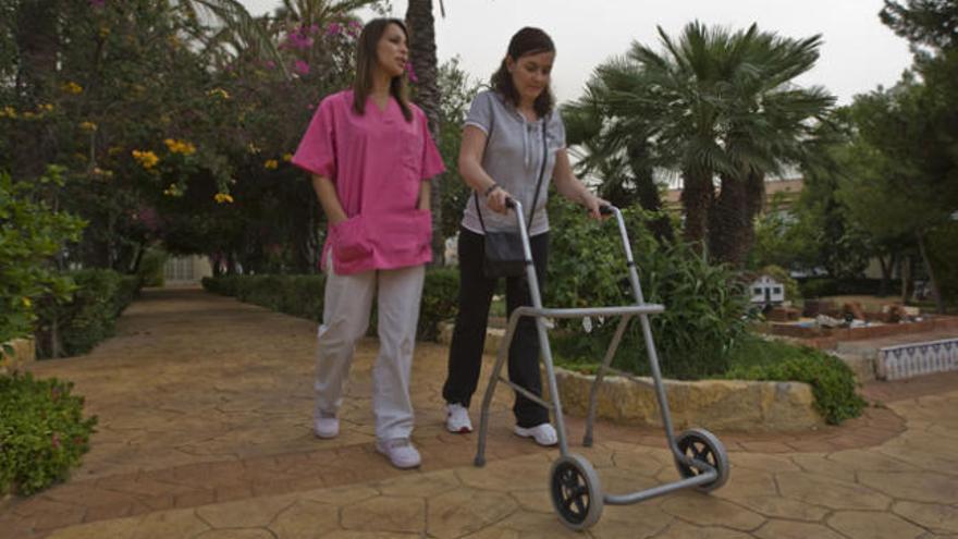 Una profesional pasea junto a una paciente.
