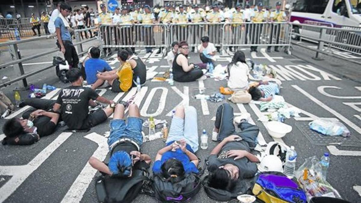 Los manifestantes bloquean una calle en las proximidades de la sede del Gobierno local de Hong Kong.