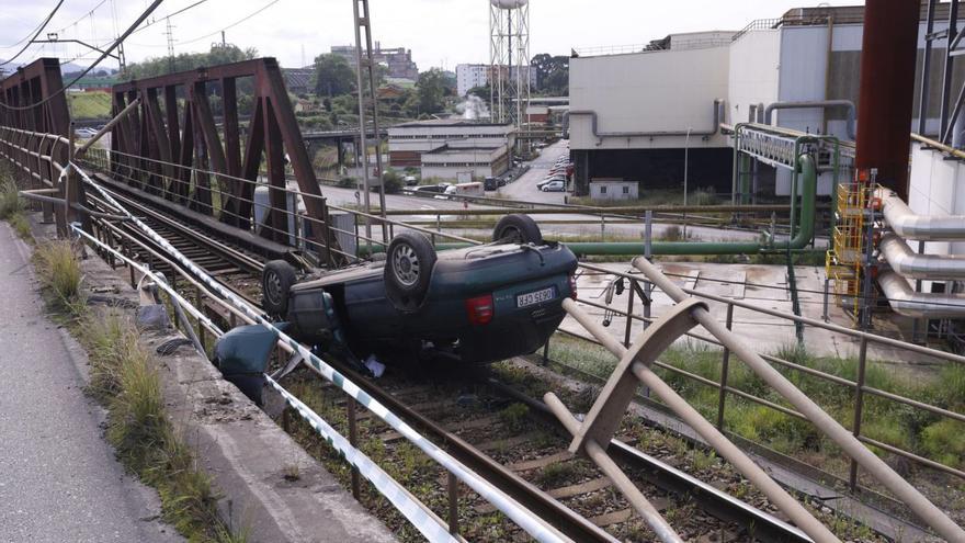 Coche accidentado en la vía de FEVE en Trasona que interrumpió el tráfico ferroviario. | LUISMA MURIAS