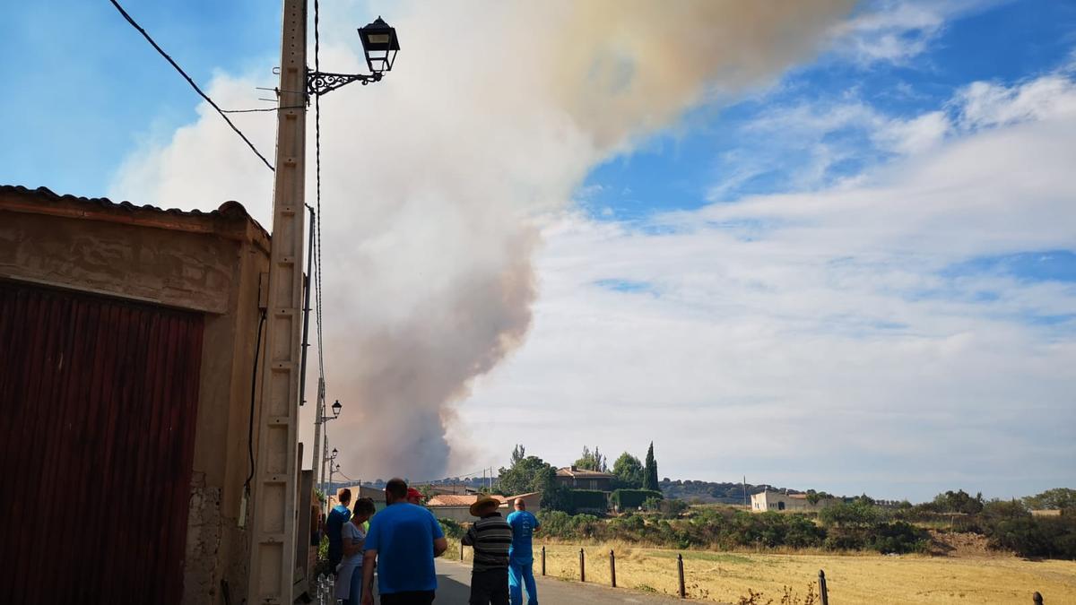 Los vecinos de Añón de Moncayo, este domingo, contemplan la columna de humo que se reavivó de repente en la zona de Maveruela.