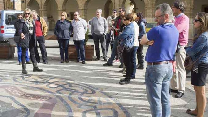 La guía explica el significado del mosaico de la Plaza Mayor.