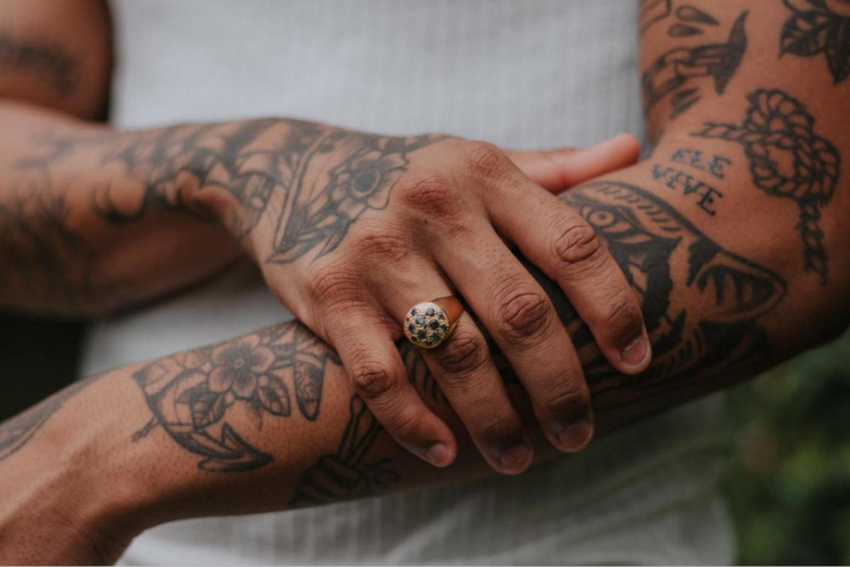 Una persona muestra sus brazos tatuados