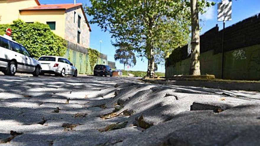 Calzada en mal estado en la urbanización O Carón, en A Zapateira.