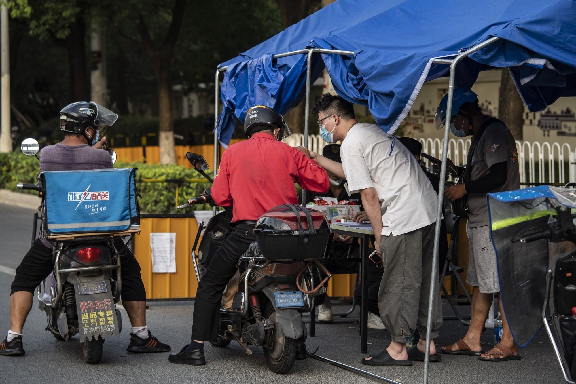 Covid Measures in Shanghai Delivery drivers pass through a security checkpoint as several city blocks are sealed off due to Covid-19 in the Meilong township of Shanghai, China, on Monday, Aug. 15, 2022. Shanghai’s 25 million residents are well versed in lockdowns, after being barred from leaving their homes for two months this spring in an effort to eradicate the virus. Photographer: Qilai Shen/Bloomberg  SHANGHAI [Municipio]