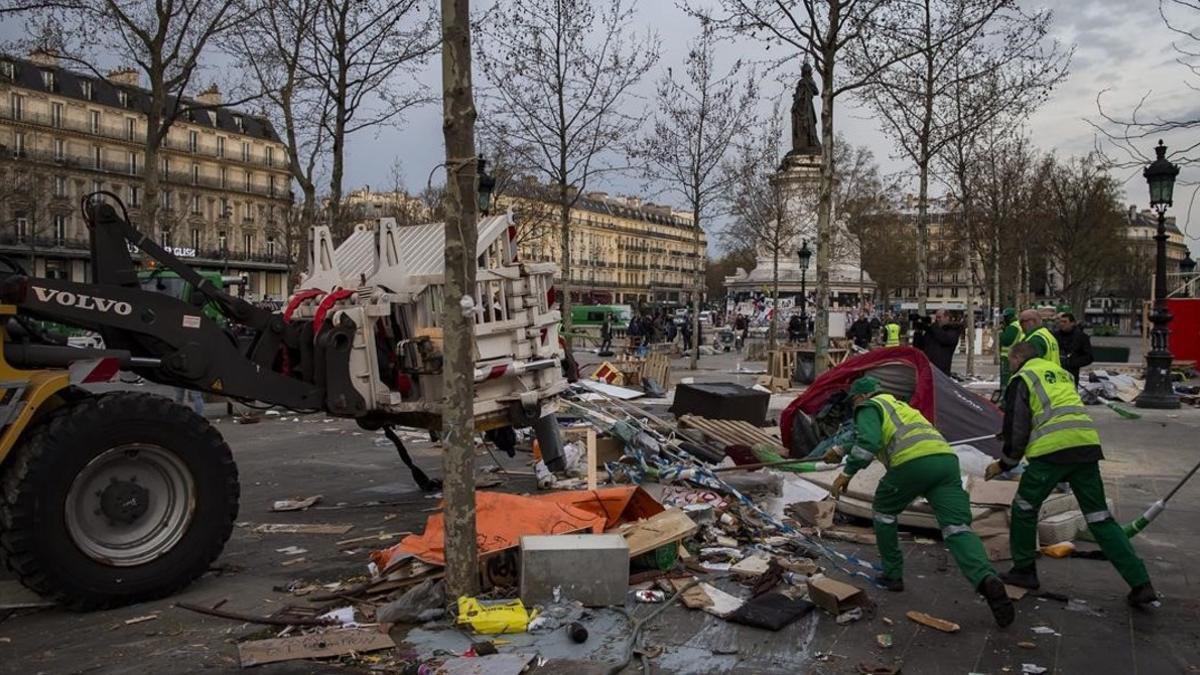 Empleados municipales limpian la plaza de la República después de que los gendarmes evacuaran a los indignados, este lunes, en París.