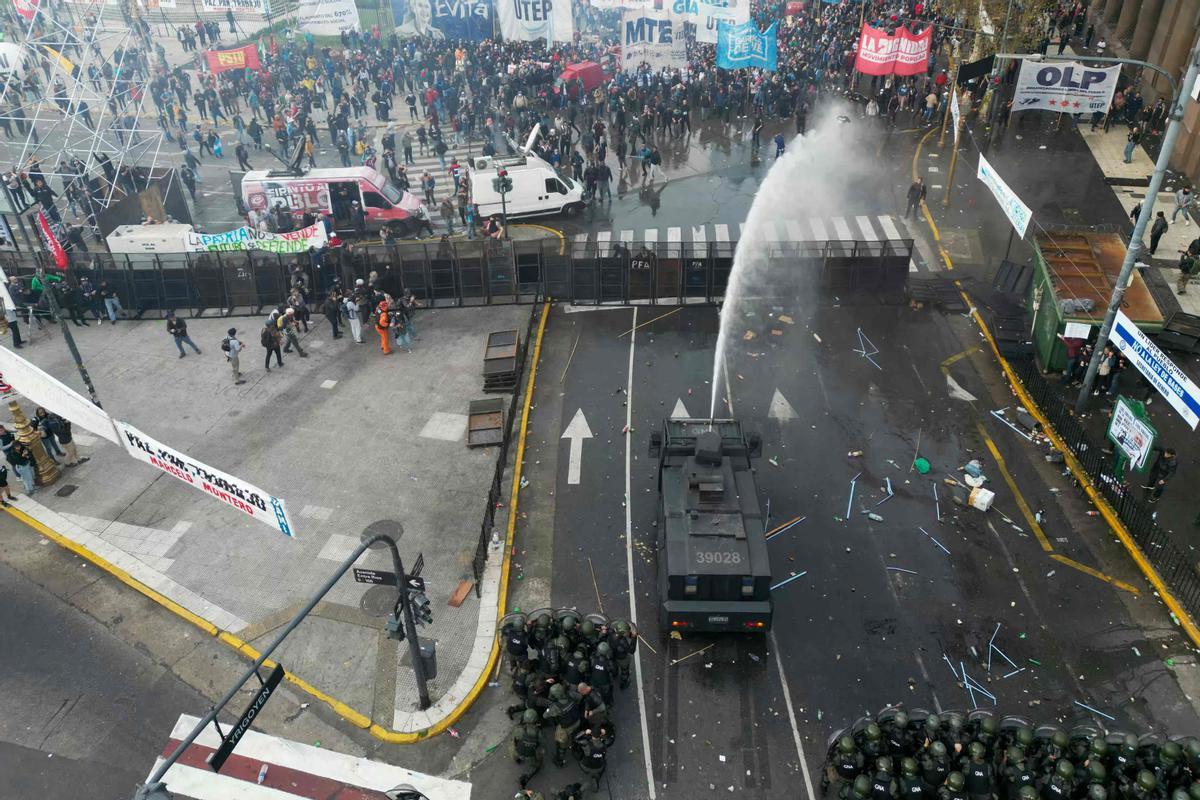 Manifestantes chocan con la policía antidisturbios frente al Congreso Nacional en Buenos Aires el 12 de junio de 2024. Los senadores argentinos debaten un paquete de reformas clave para el presidente ultraderechista Javier Milei, en una sesión marcada por huelgas y manifestaciones frente al Congreso.