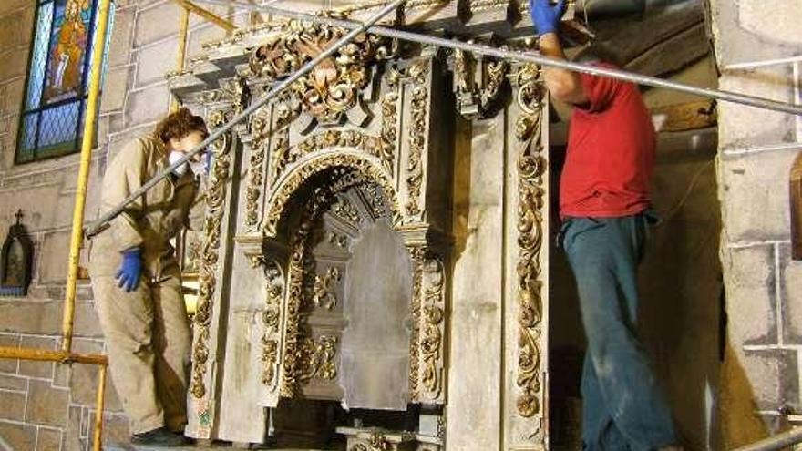 Almudena Salgado y Regis Soler desmontan el retablo. // A.R,