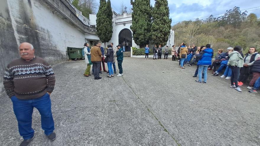 Vecinos y responsables políticos,  ayer, frente a la entrada del cementerio de El Entrego. | D. M.