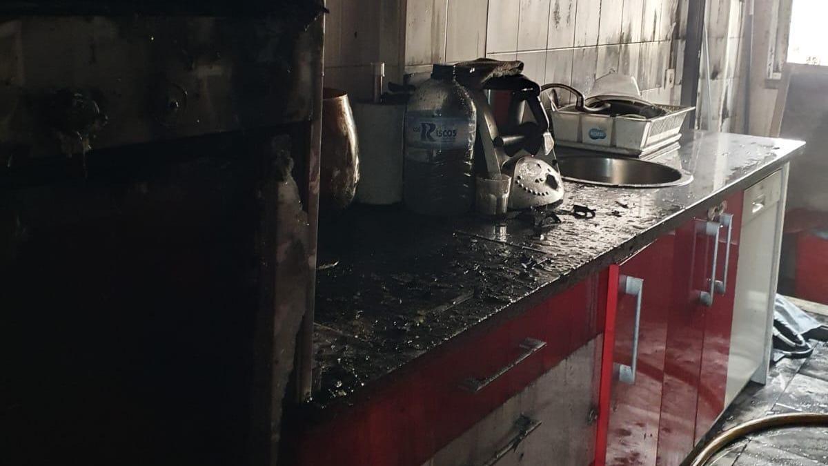 La cocina de la vivienda, muy afectada por el fuego.