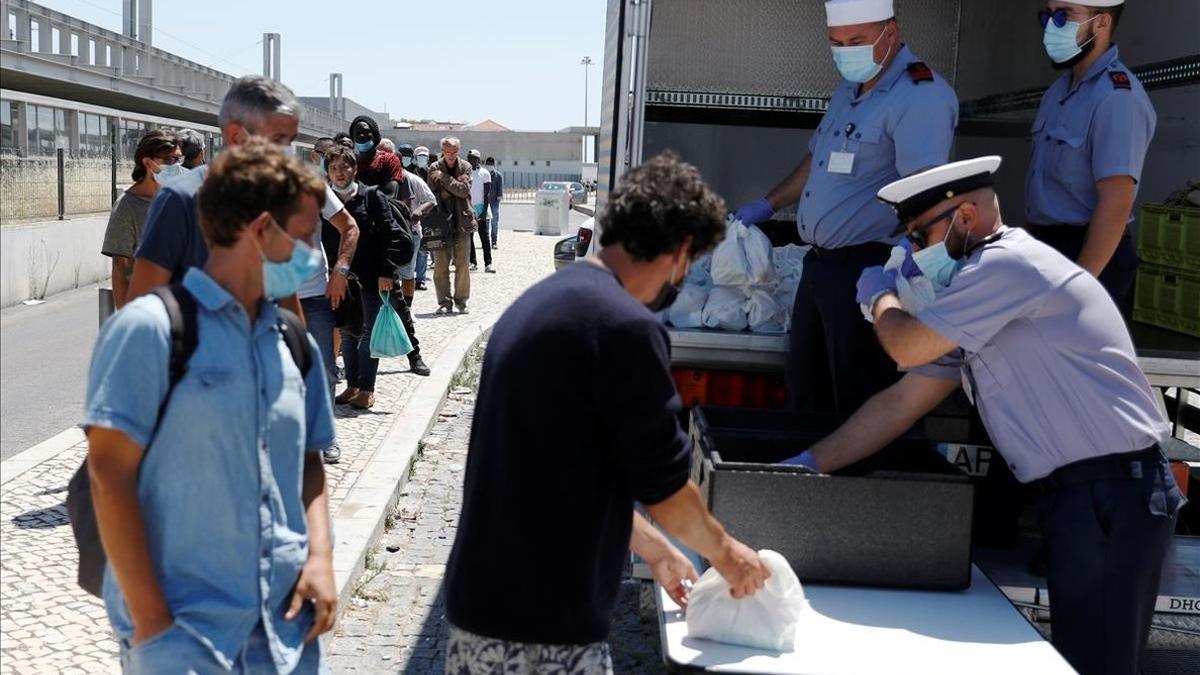 Miembros de la Marina de Portugal reparten comida entre ciudadanos necesitados por la pandemia.