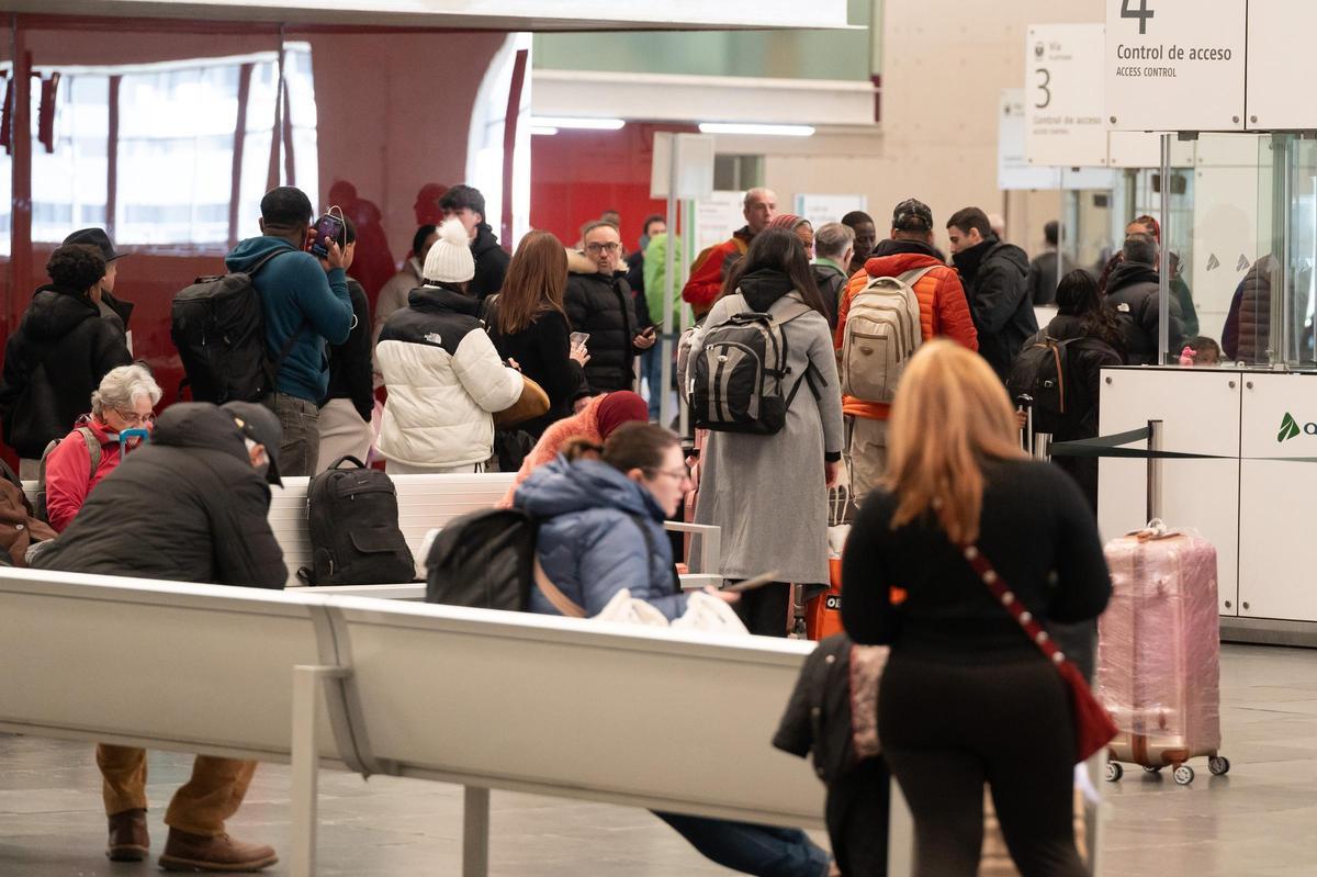 Varios pasajeros esperan la salida de sus trenes en la estación Delicias este lunes.