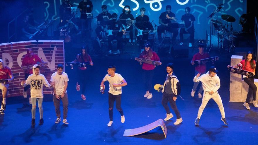 Una de las coreografías del musical “Skate hero”, con los actores en primer término y los músicos al fondo, tocando la música en directo. | Jose Luis Fernández
