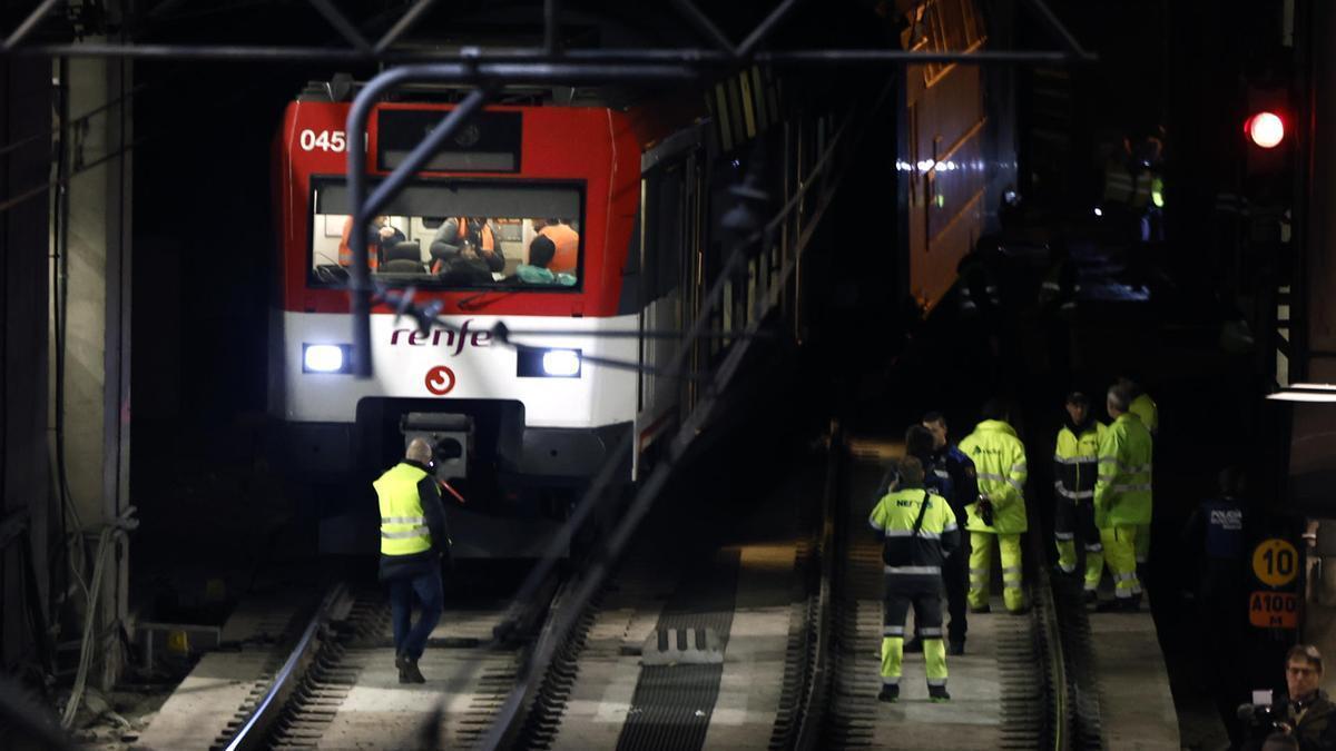 Operarios junto al tren que descarriló en su entrada a Atocha.