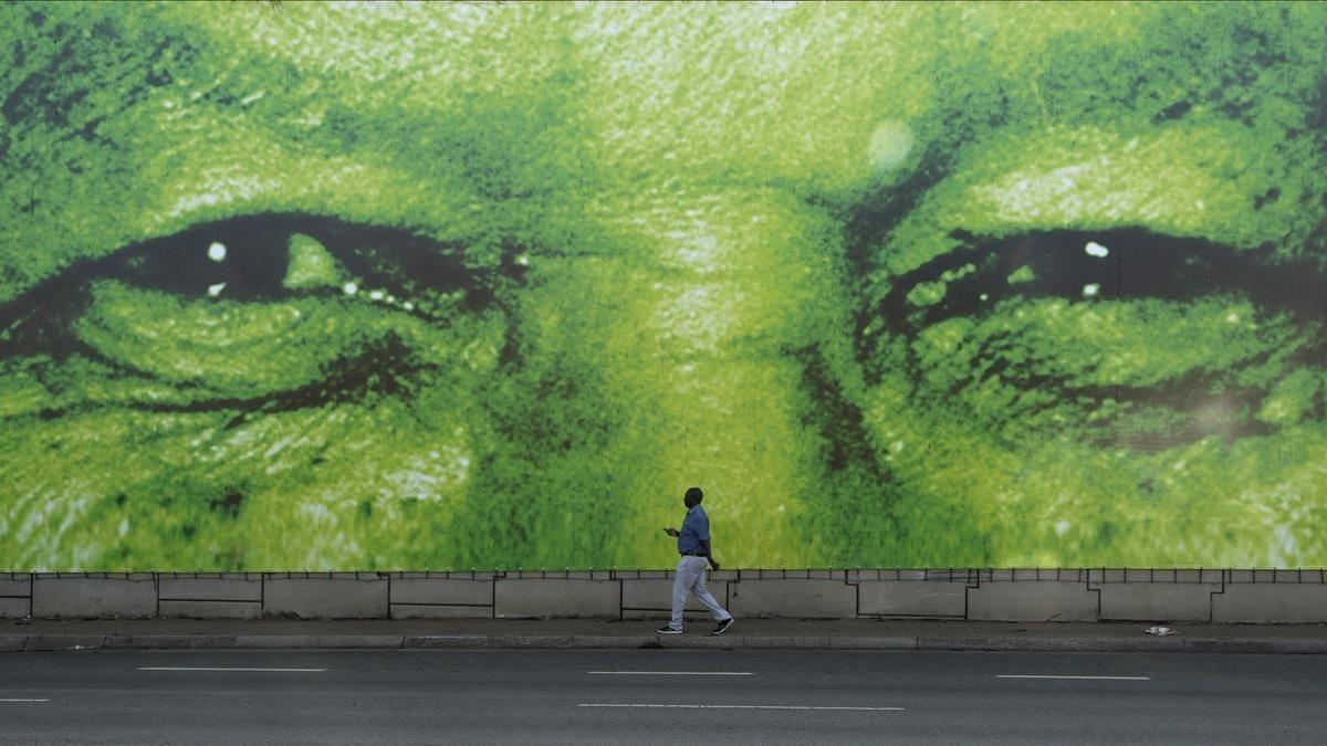 Un hombre pasa en frente de un mural del historico presidente sudafricano