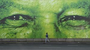 Un hombre pasa en frente de un gigante mural del histórico presidente sudafricano, Nelson Mandela. 