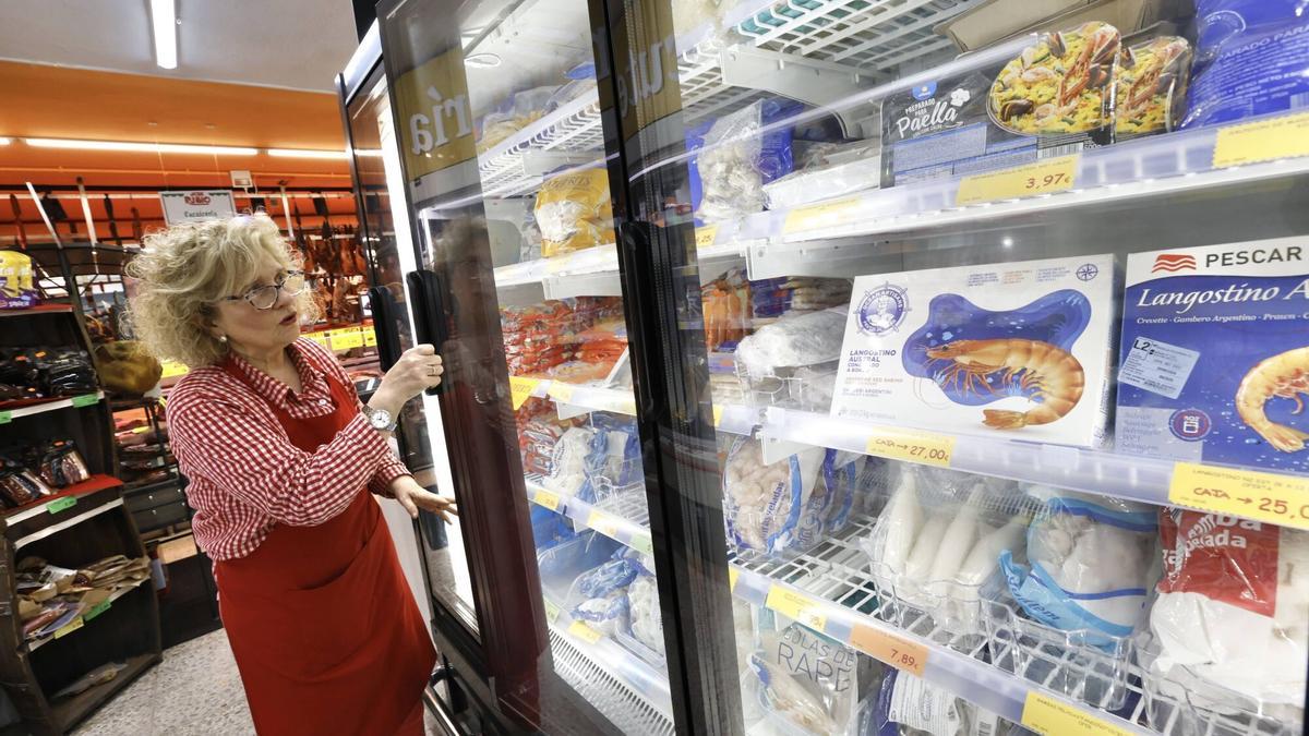 -Esther Rubio, en el supermercado que regenta en el barrio avilesino de La Carriona, ante diferentes productos.
