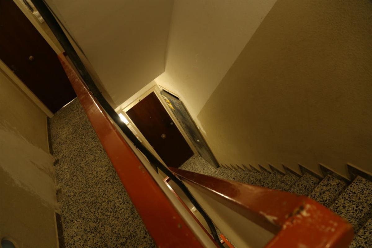 Interior del bloc de pisos del carrer Floridablanca de Mataró amb pisos ocupats per grups organitzats. El cable negre forma part de la instal·lació provisional posterior a l’incident elèctric que es va produir a l’edifici.