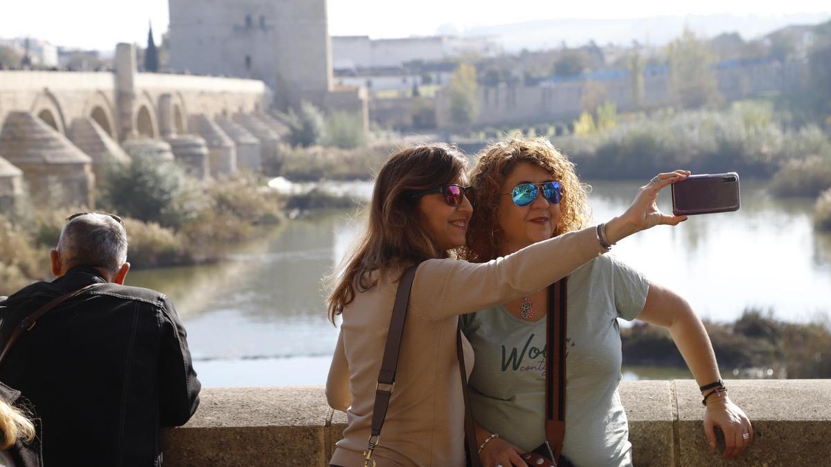 Dos turistas se hacen un ‘selfie’ en el entorno del Puente Romano de Córdoba.