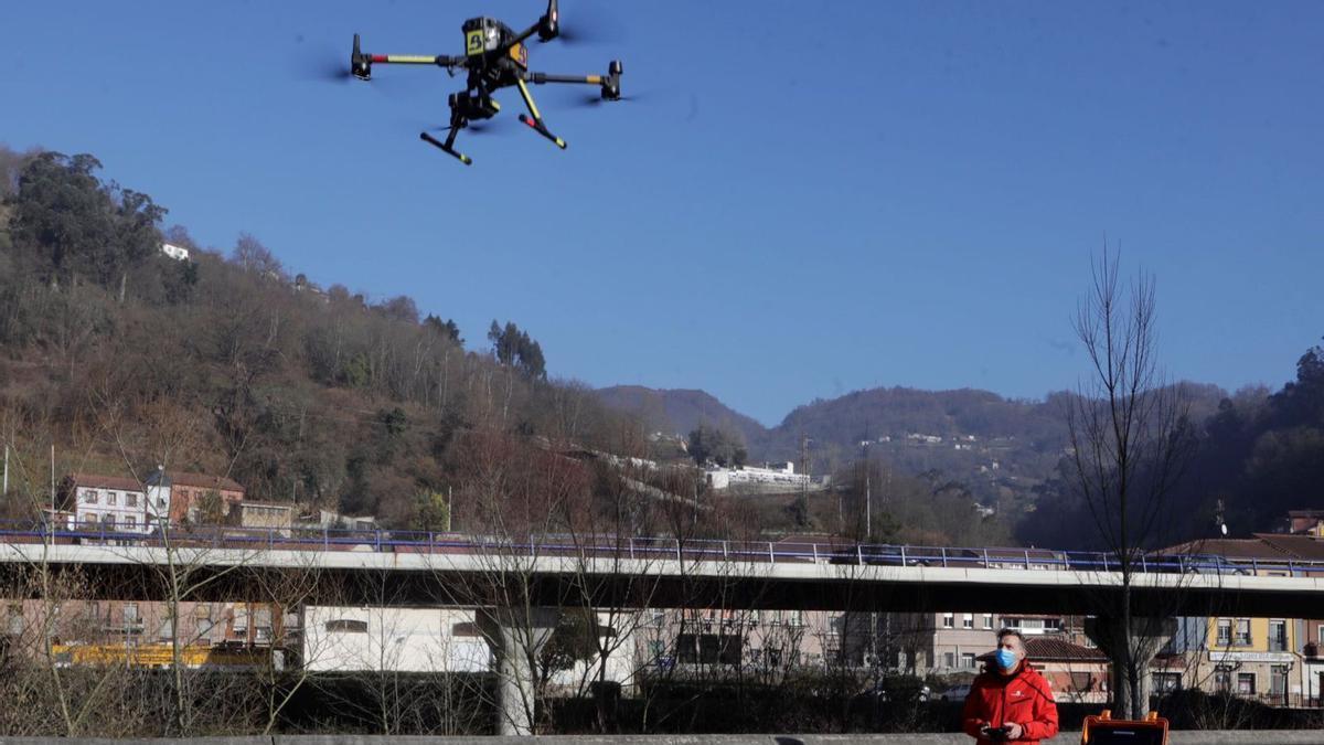 Un técnico maneja un dron multirrotor en el parque de La Laguna, en El Entrego..