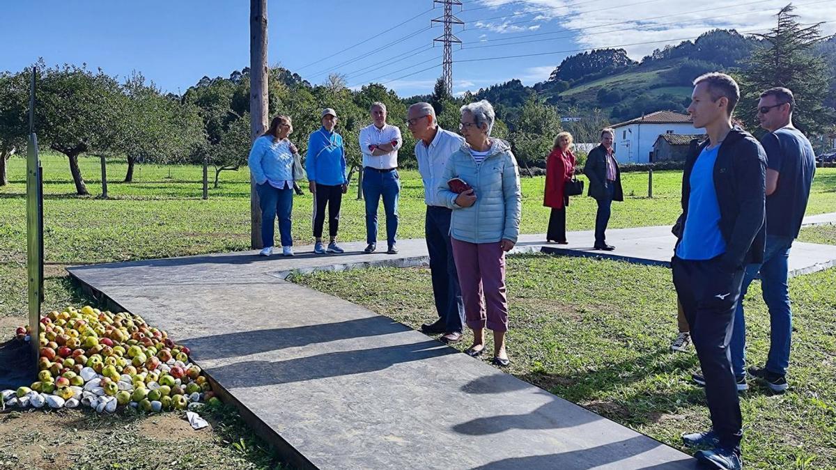 Turistas y vecinos contemplan la escultura en la que se instaló la placa de Arroes.