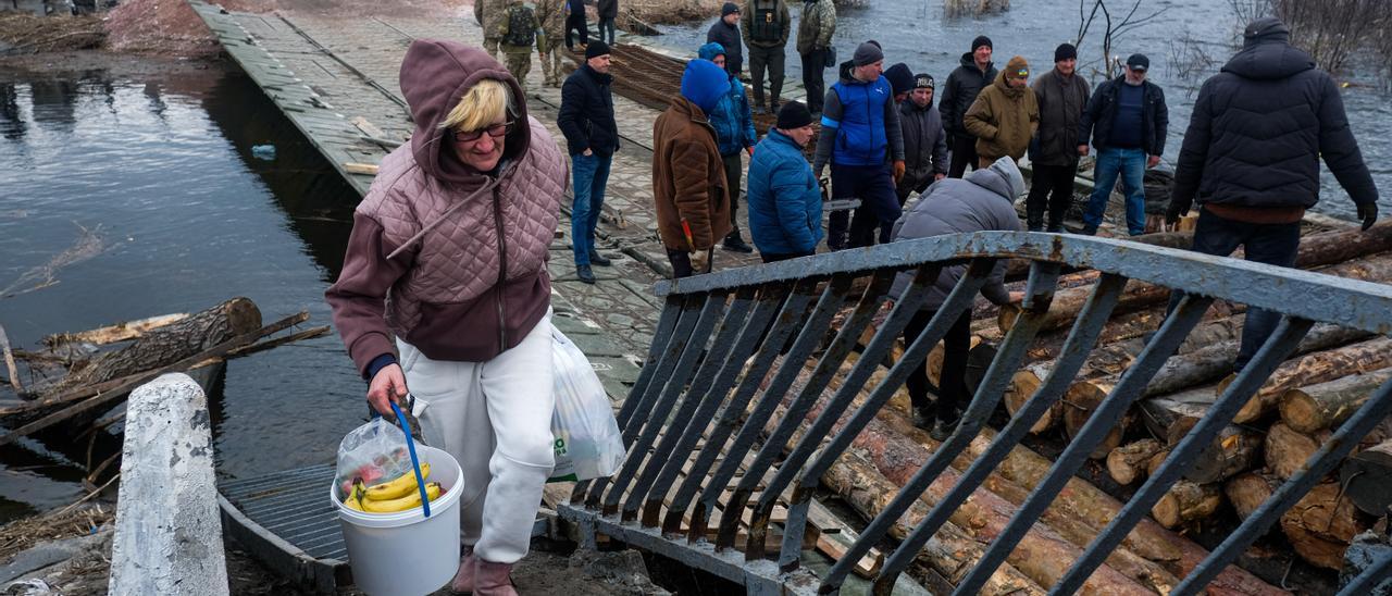 Civiles ucranianos escapan de los combates en Ucrania a través del río Irpin