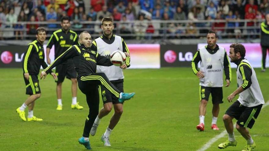 Iniesta con el balón, rodeado de varios compañeros, en el entrenamiento de ayer.