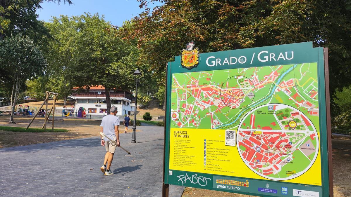 Vista del parque de Arriba de Grado, con un panel indicador de las calles de la villa.