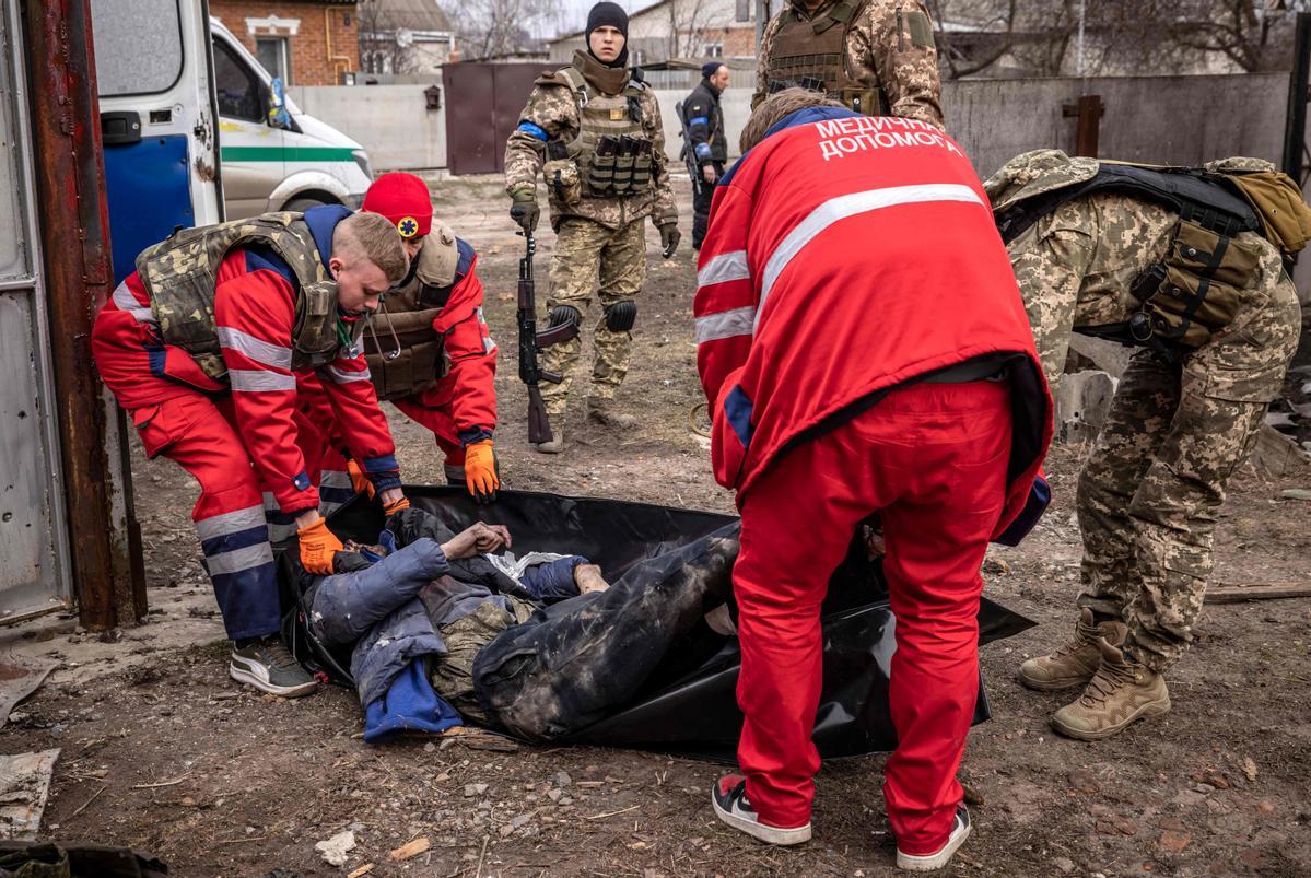 Médicos ucranianos llevan el cuerpo de un soldado ruso después de que las tropas ucranianas retomaran la aldea de Malaya Rohan, al este de Kharkiv.