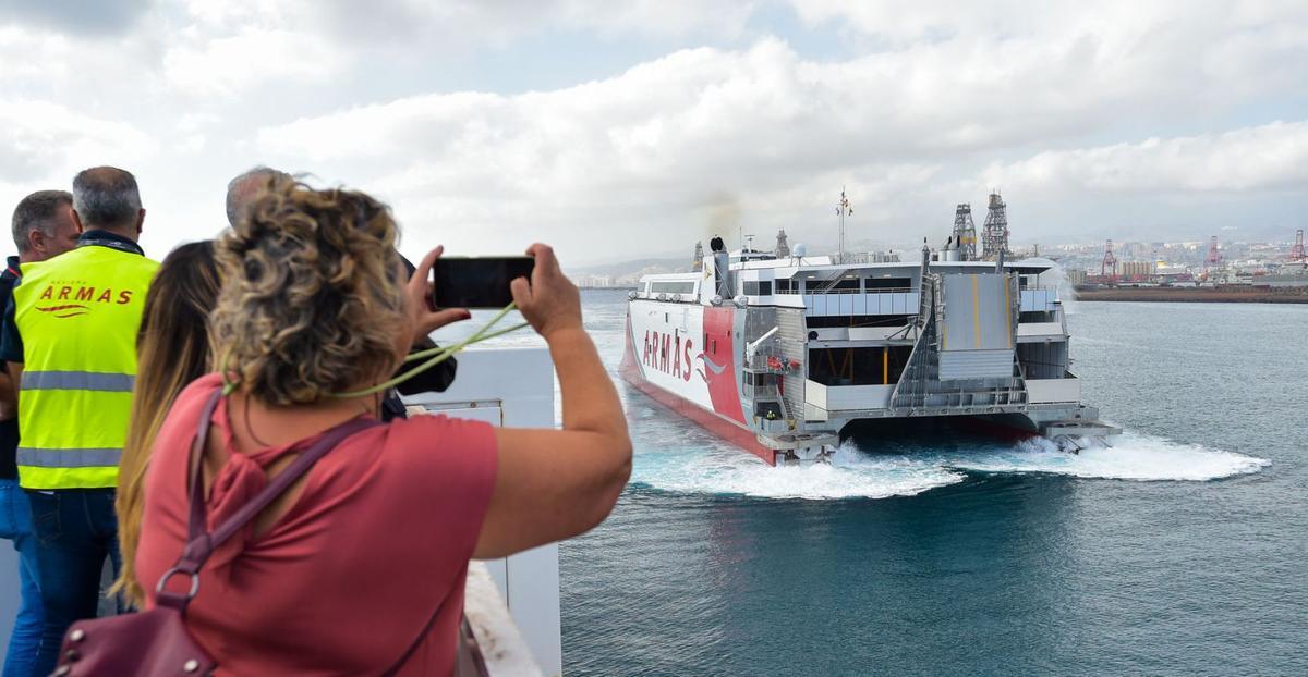 Una mujer fotografía un catamarán de la Naviera Armas a su salida del puerto. | | ANDRÉS CRUZ