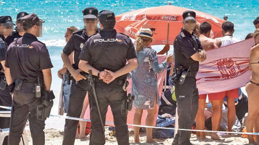 Un grupo de policías, junto al cuerpo de la víctima, en la playa de Cala Major.