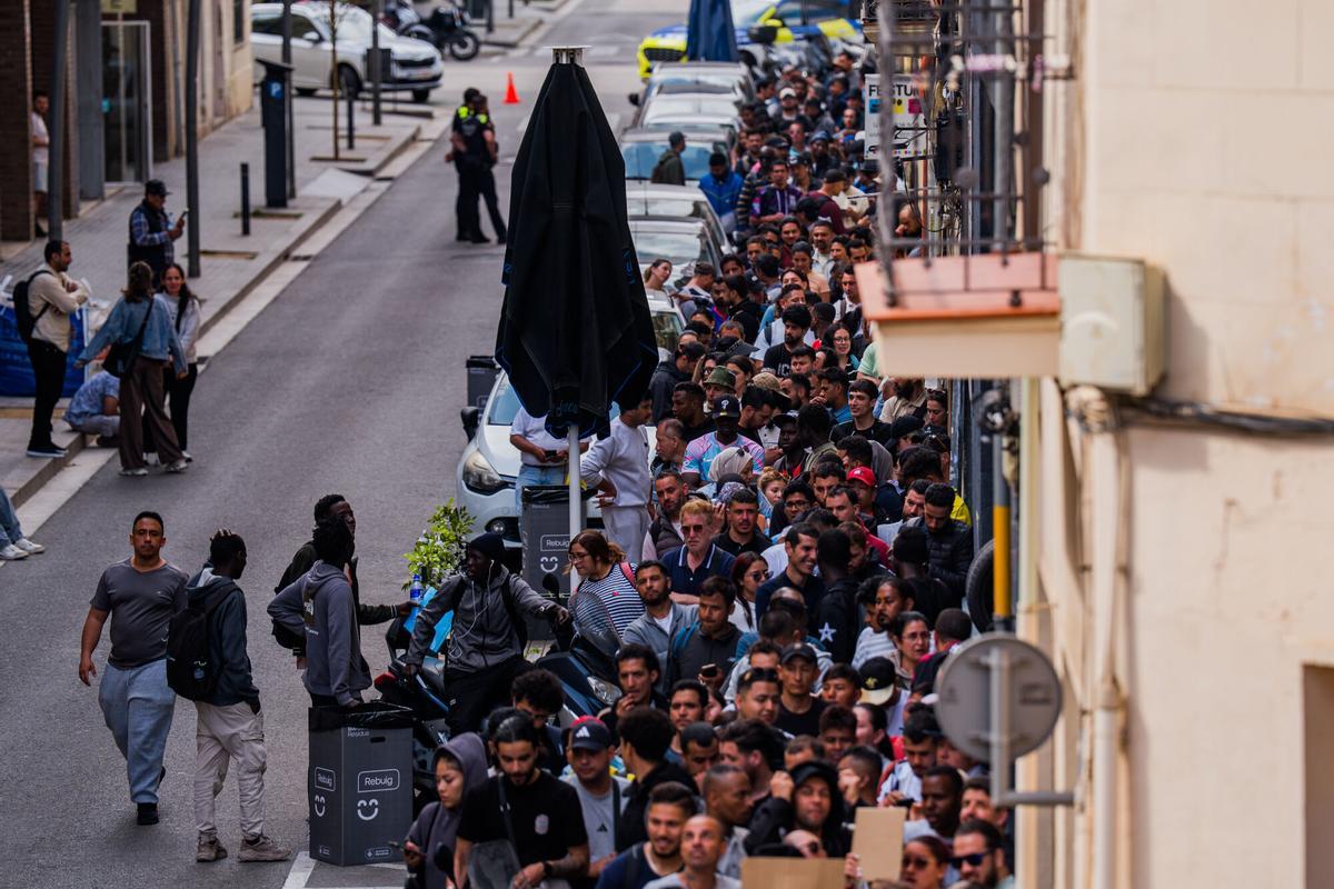 Un grup de migrants fa cua per a la regularització extraordinària.