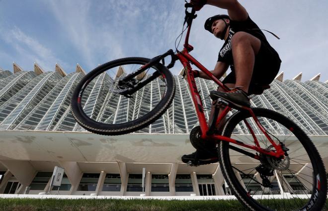 Un ciclista hace un caballito ante el Museo de las Ciencias de Valencia.