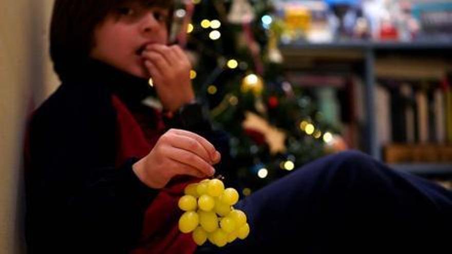 Un niño de ocho años, con un racimo de uvas.