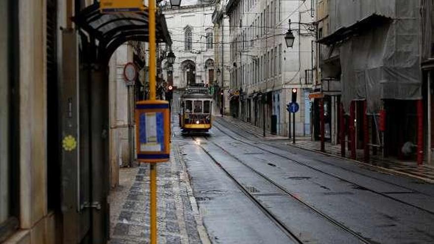 Un tranvía circula por una calle desierta de Lisboa. // Reuters